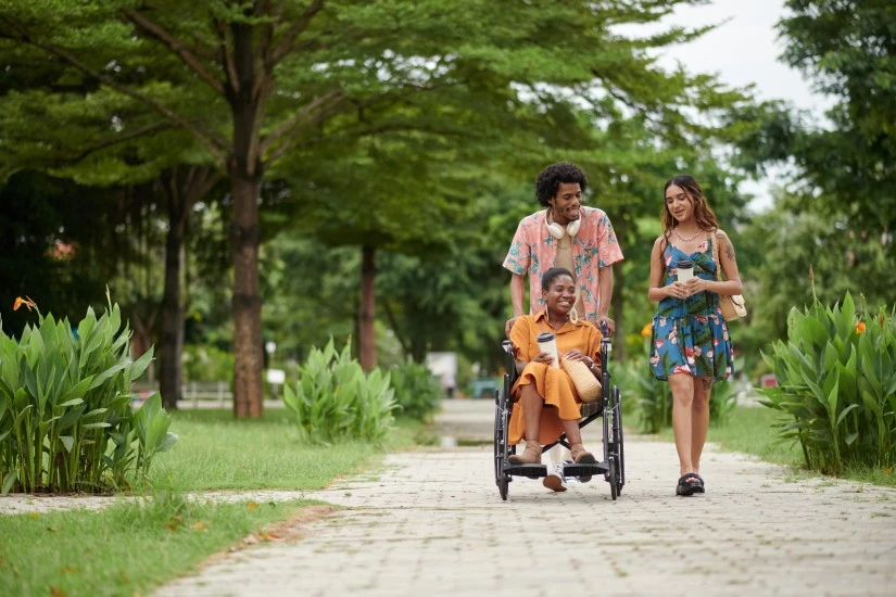 Group of friends, one disabled in wheelchair, walking outside and talking